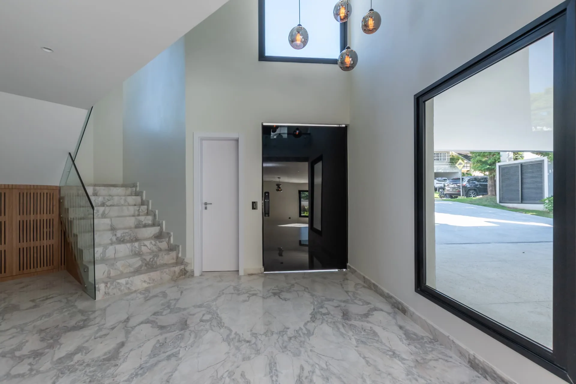 Hall de entrada com escada em mármore e pé-direito duplo