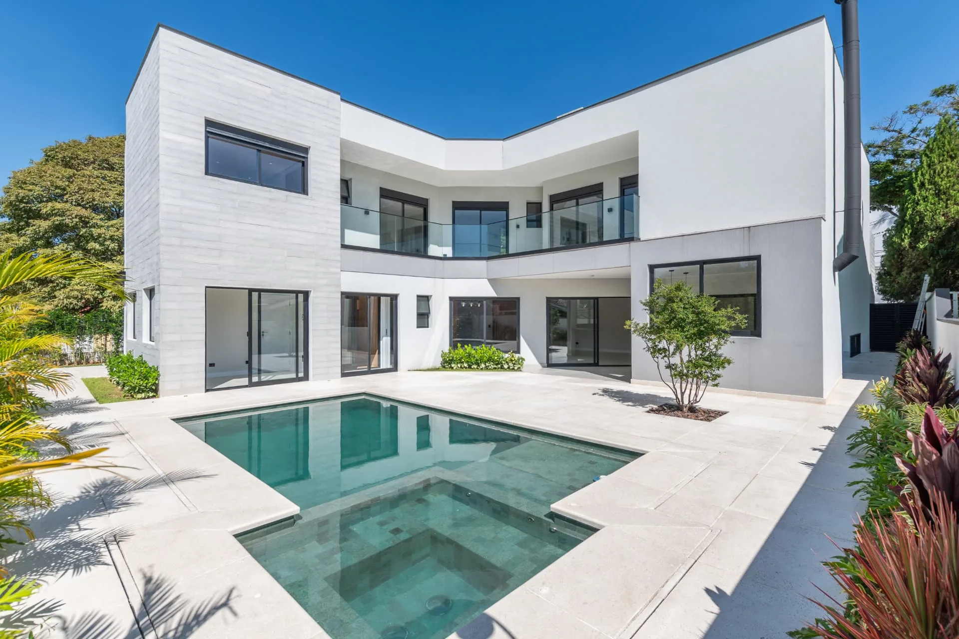 Fachada posterior com piscina, spa e área externa em porcelanato