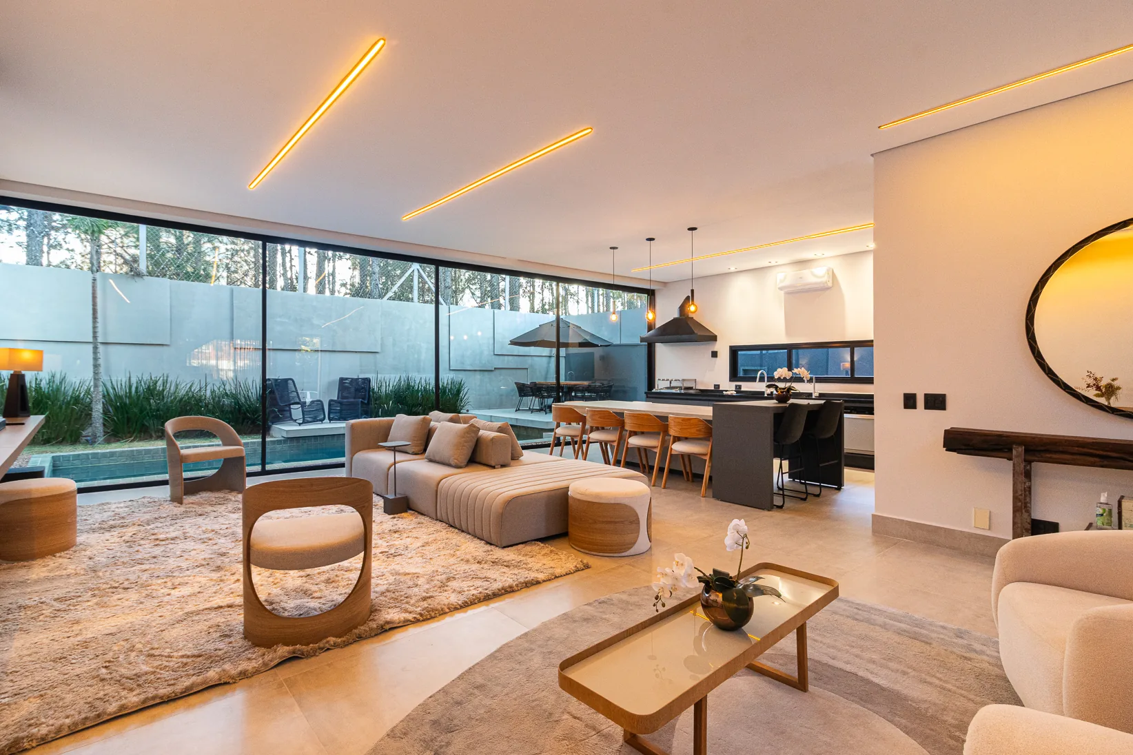 Living integrado ao espaço gourmet e cozinha, com vista para a piscina
