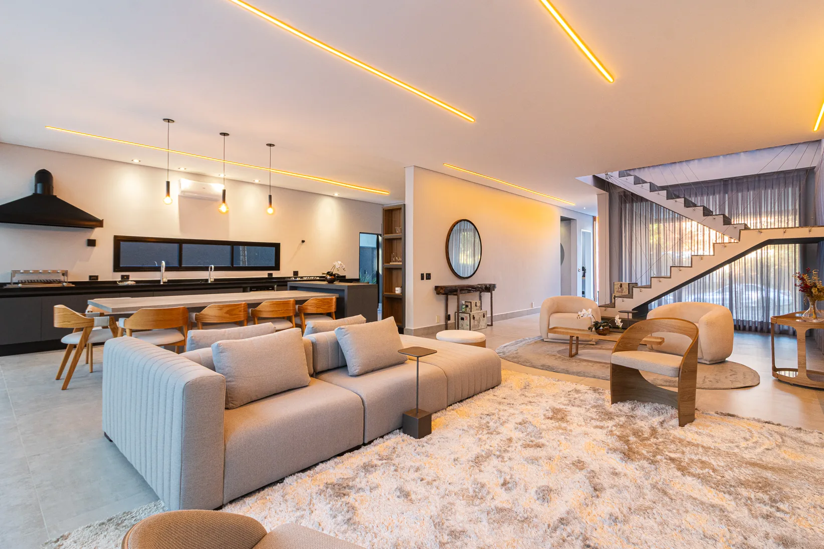 Living com escada flutuante e iluminação linear embutida