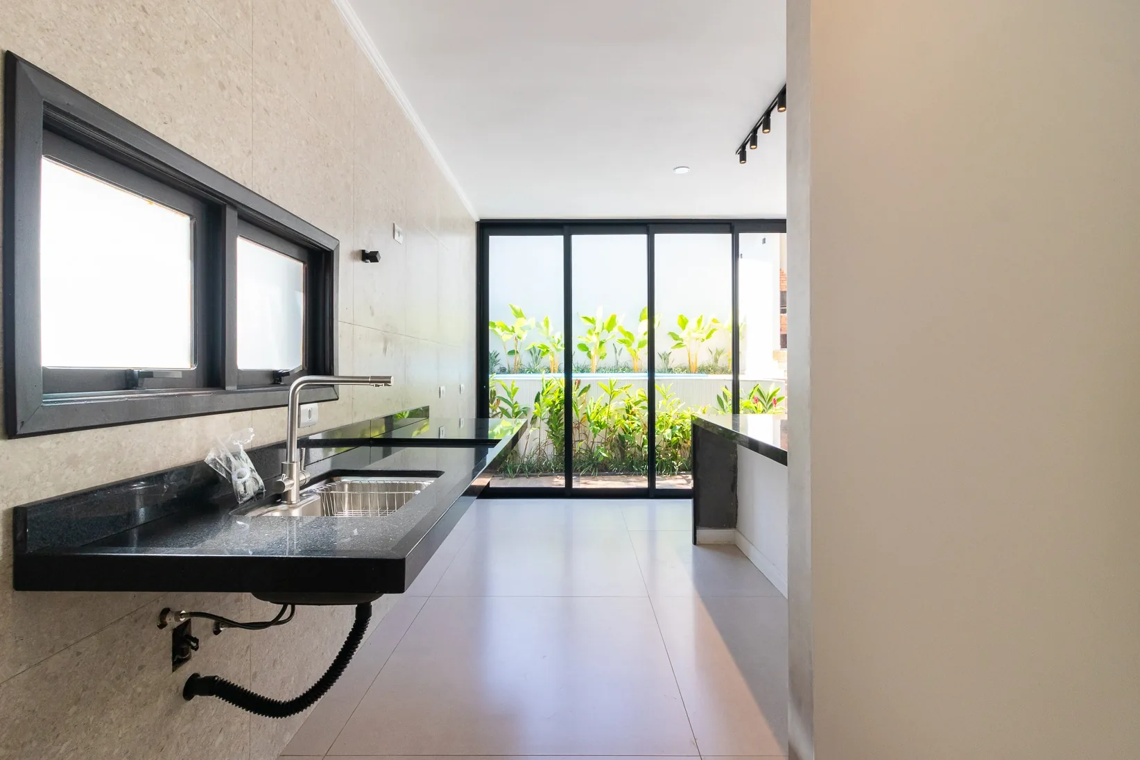 Cozinha com bancadas em granito e vista para o jardim