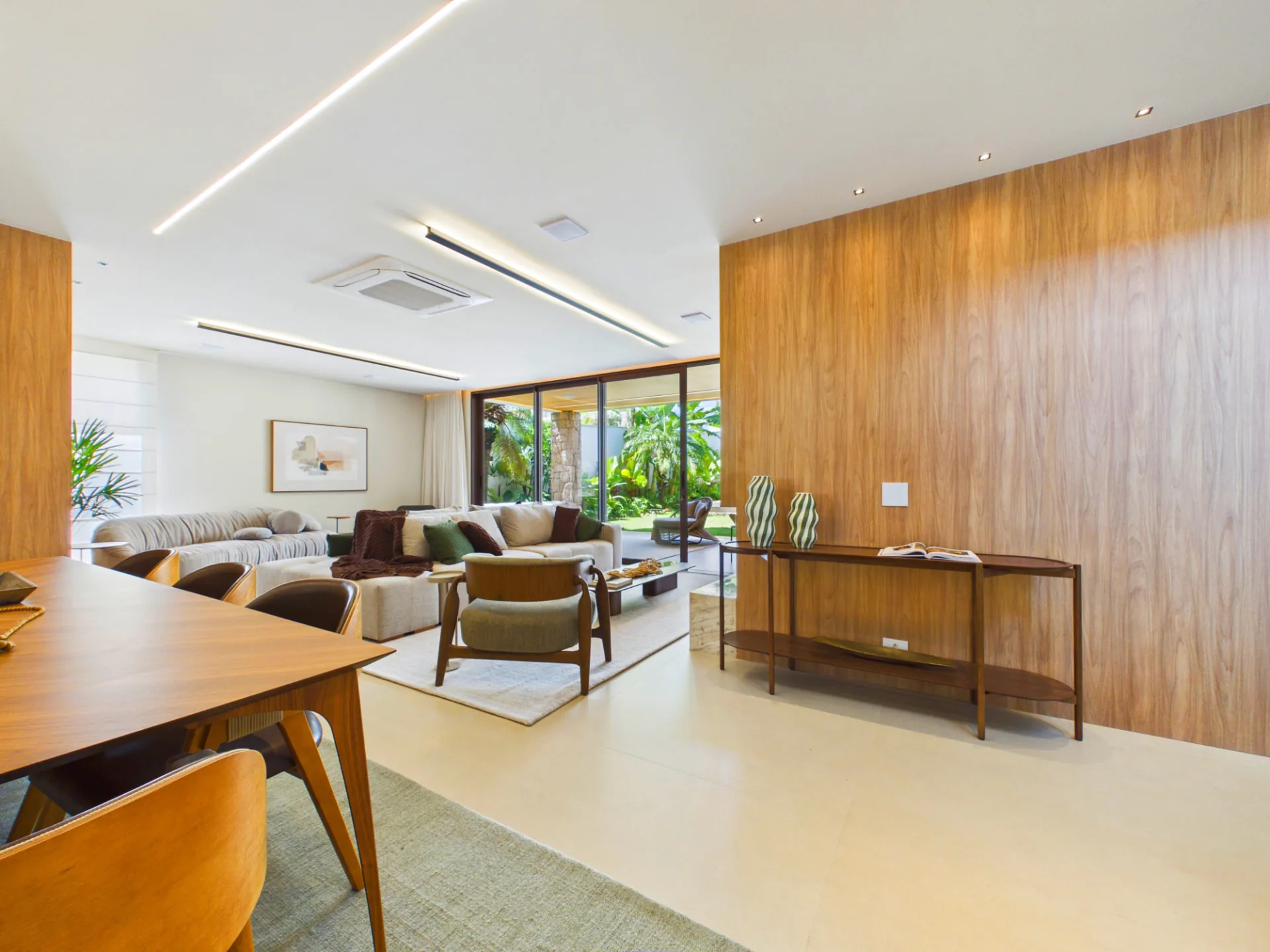 Sala de jantar integrada ao living com painel de madeira