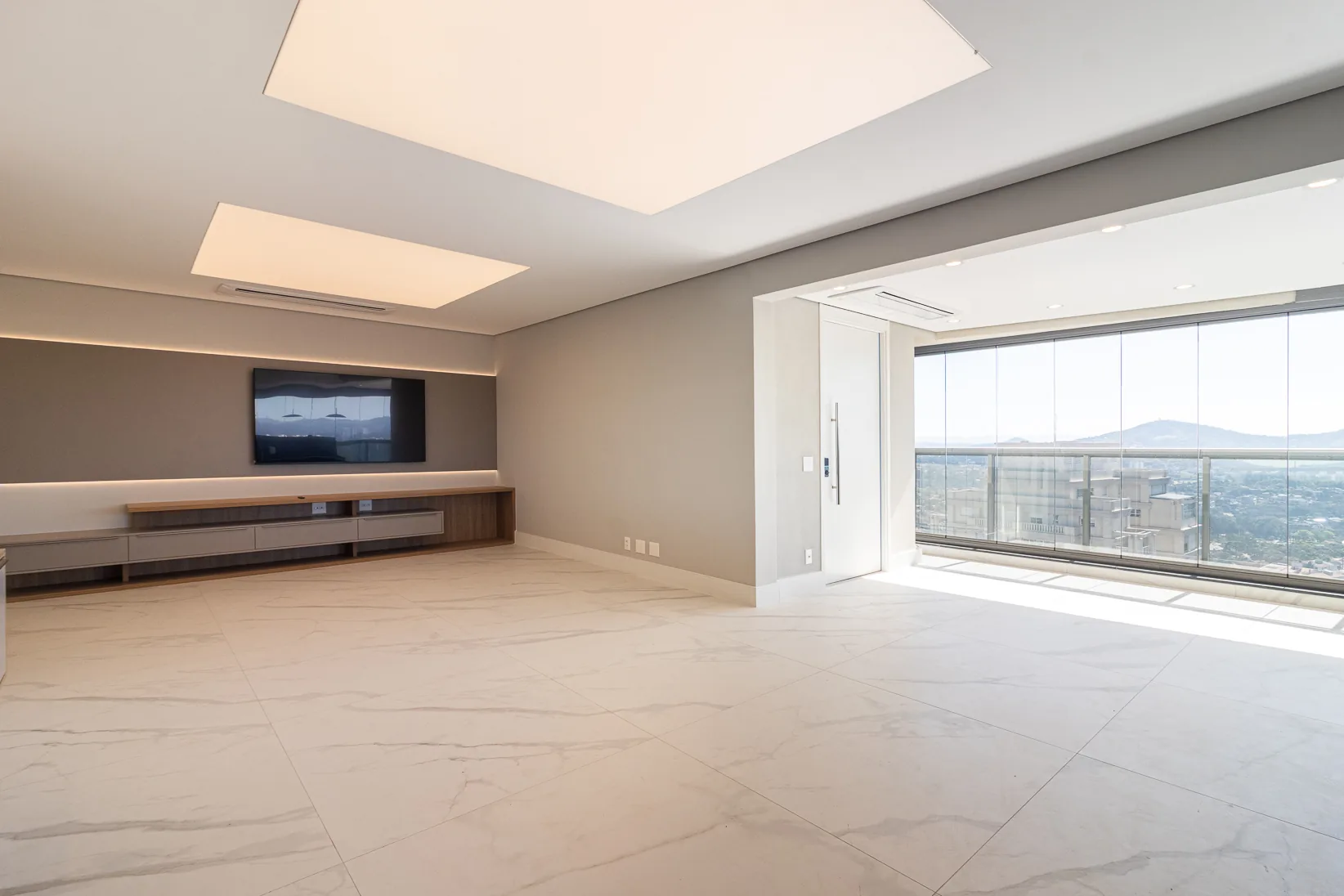 Sala de estar com rack em madeira e vista para a cidade