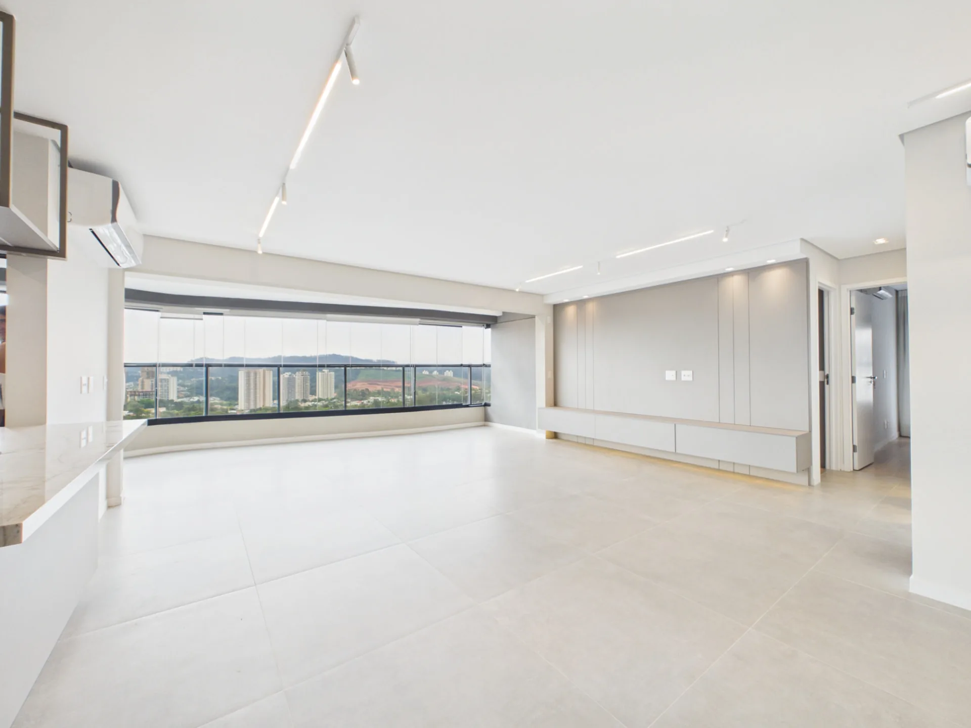 Sala ampla integrada à varanda, com vista aberta