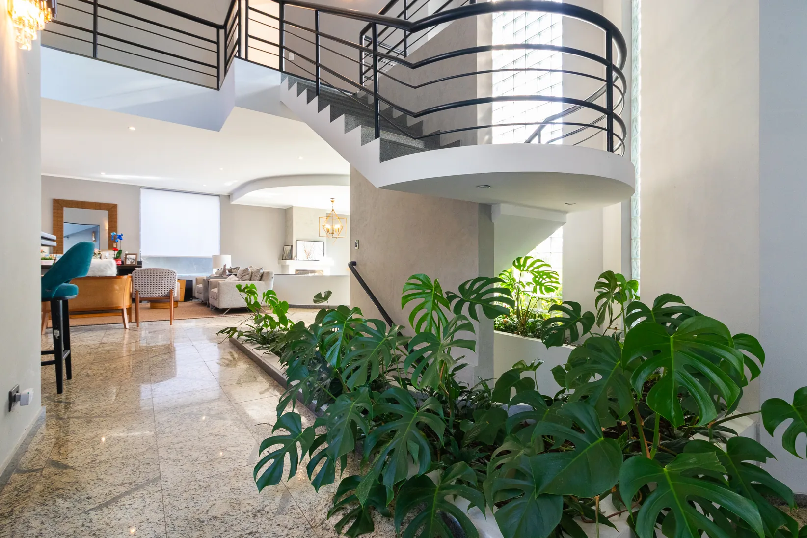Hall interno com escada e jardim