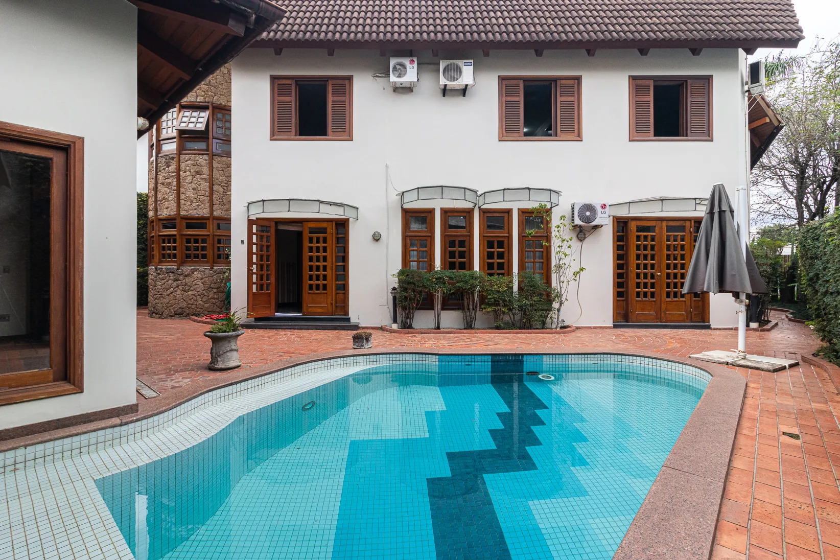 Área externa atual com piscina e piso cerâmico